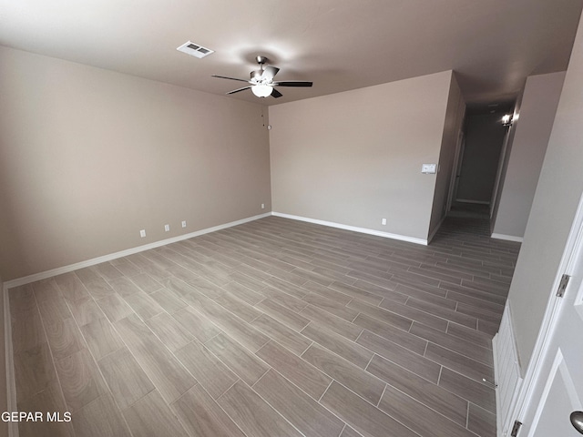 unfurnished room with wood finish floors, visible vents, baseboards, and a ceiling fan