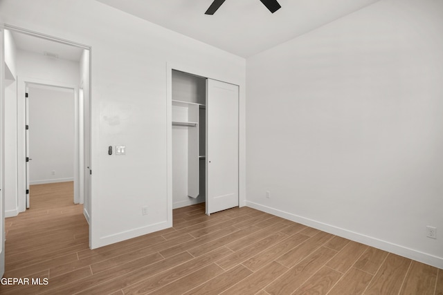 unfurnished bedroom featuring a closet, ceiling fan, light wood-type flooring, and baseboards