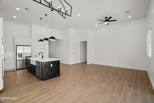 kitchen with visible vents, stainless steel fridge with ice dispenser, open floor plan, light wood-type flooring, and a sink