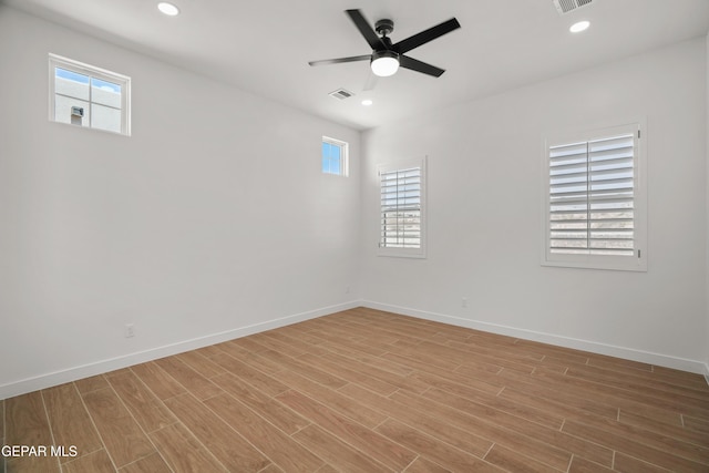 unfurnished room with visible vents, plenty of natural light, light wood-style floors, and a ceiling fan