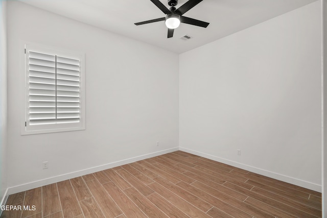 spare room featuring visible vents, baseboards, ceiling fan, and wood finished floors