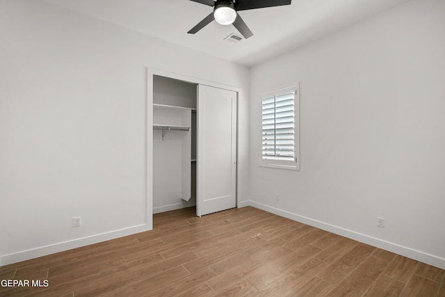 unfurnished bedroom with a closet, visible vents, light wood-style flooring, and baseboards