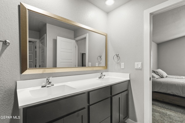 full bathroom featuring a sink, ensuite bath, double vanity, and a textured wall