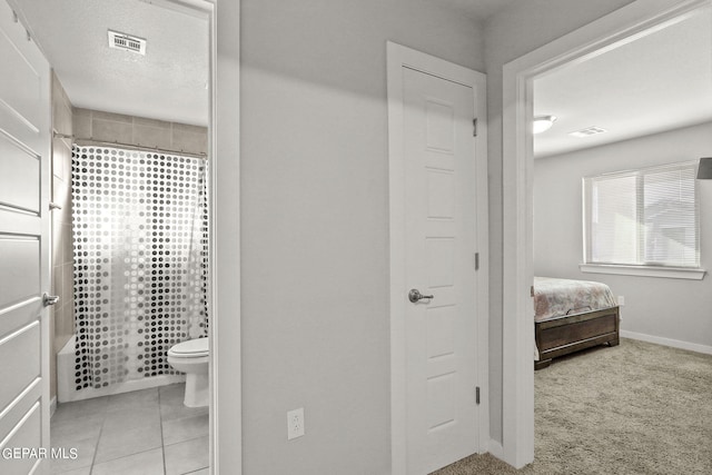 full bathroom with tile patterned floors, visible vents, a textured ceiling, and toilet