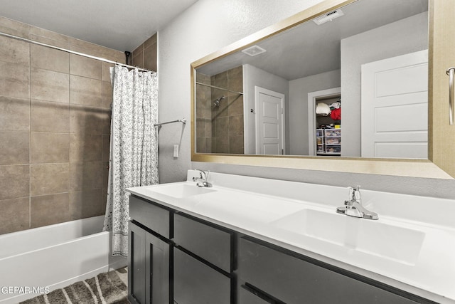 bathroom featuring double vanity, visible vents, and a sink