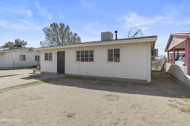 rear view of house featuring central AC and fence