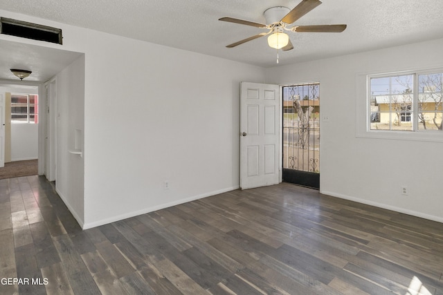 unfurnished room with baseboards, a textured ceiling, ceiling fan, and dark wood finished floors