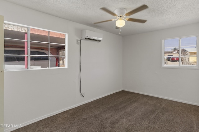 empty room with a textured ceiling, a ceiling fan, a wall unit AC, and carpet floors