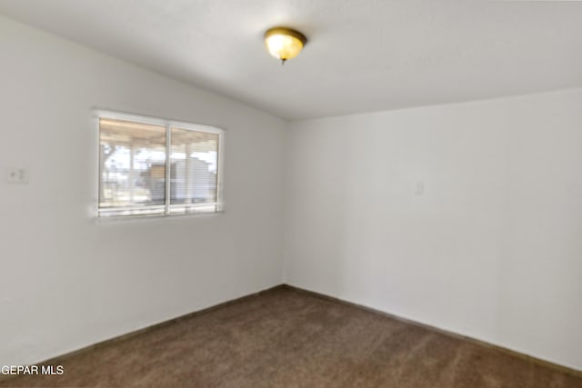 unfurnished room featuring dark colored carpet