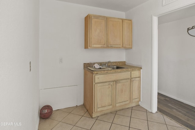 kitchen with a sink, light tile patterned flooring, and light brown cabinetry