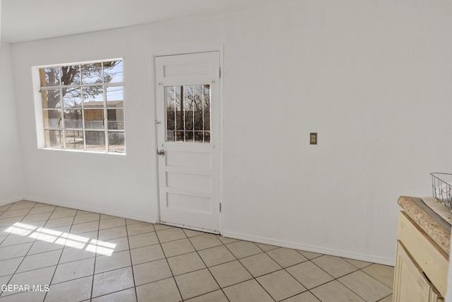 entrance foyer with light tile patterned floors and baseboards