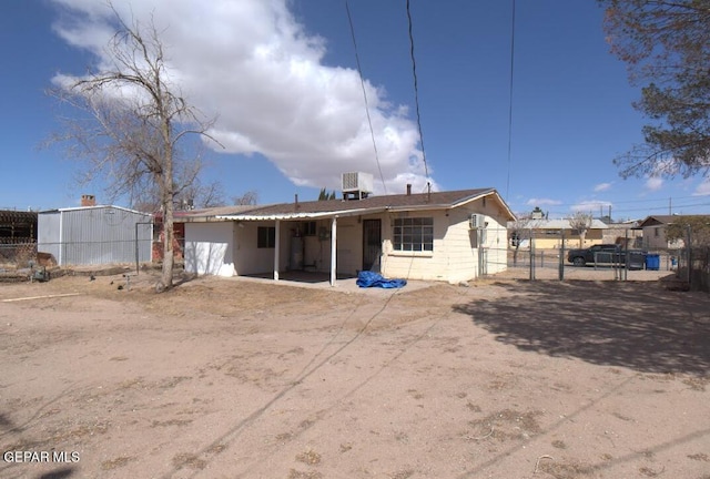 rear view of property with a gate, central AC unit, and fence