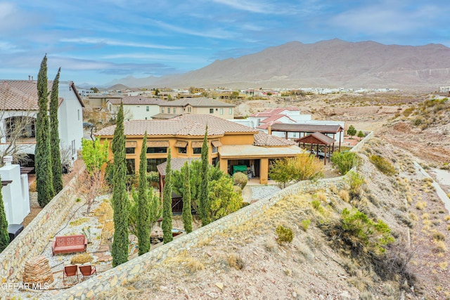 exterior space featuring a mountain view, a residential view, stucco siding, and a tile roof