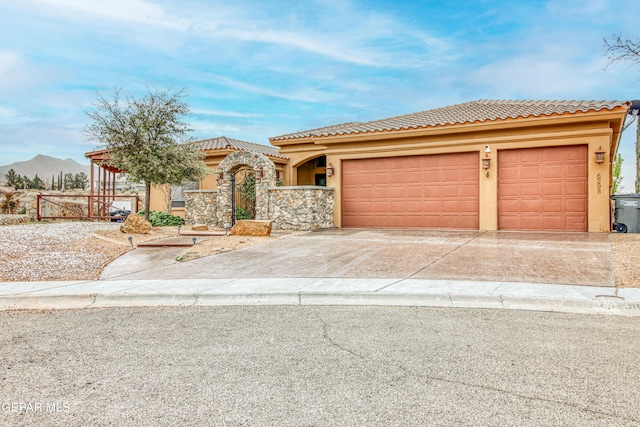 view of front facade with fence, a tiled roof, stucco siding, driveway, and an attached garage