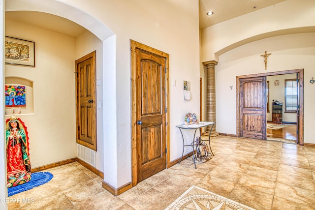 foyer with visible vents, baseboards, and arched walkways