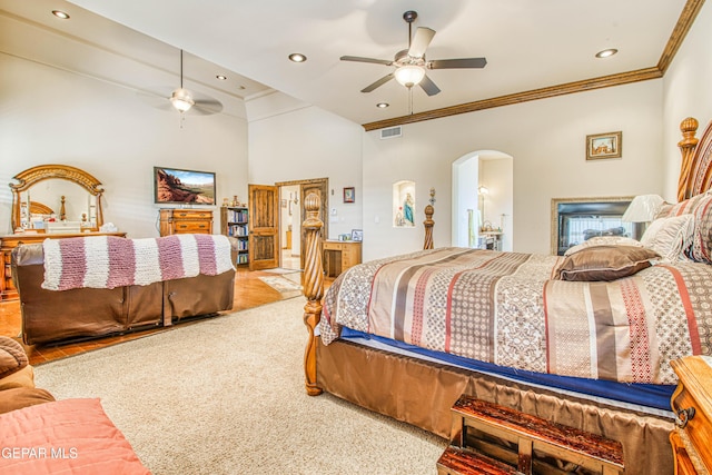 bedroom with arched walkways, visible vents, carpet flooring, and ornamental molding