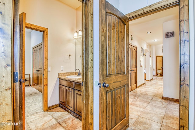 hallway featuring a sink and baseboards