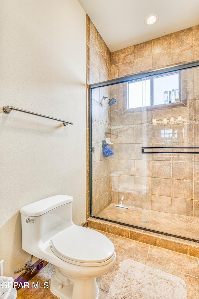 bathroom featuring a shower stall and toilet