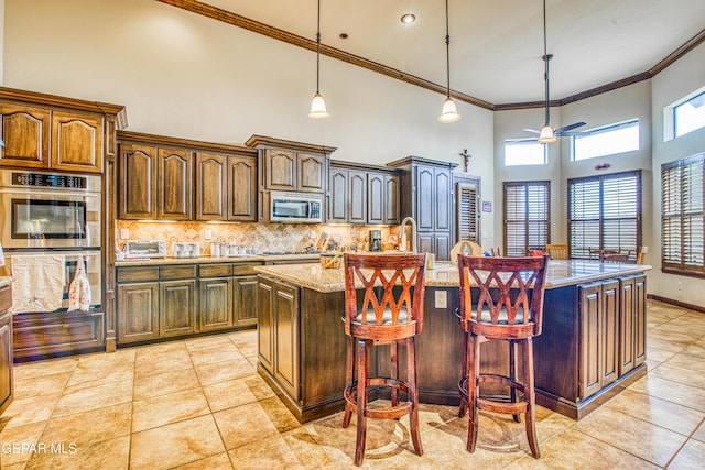 kitchen featuring light tile patterned floors, backsplash, appliances with stainless steel finishes, and a ceiling fan