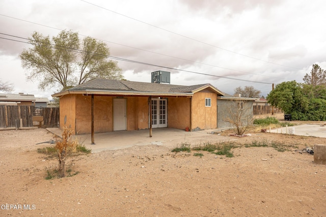 back of property with stucco siding, french doors, a patio, and fence