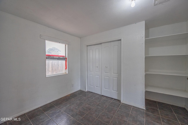 unfurnished bedroom with visible vents, baseboards, and a closet