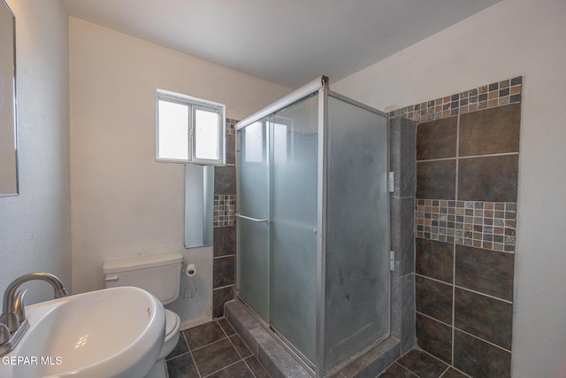 full bath with a shower stall, toilet, tile patterned floors, and a sink