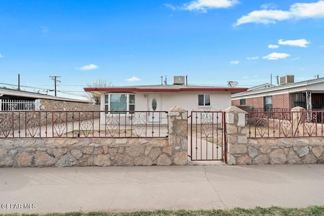 view of front of house with a fenced front yard and a gate