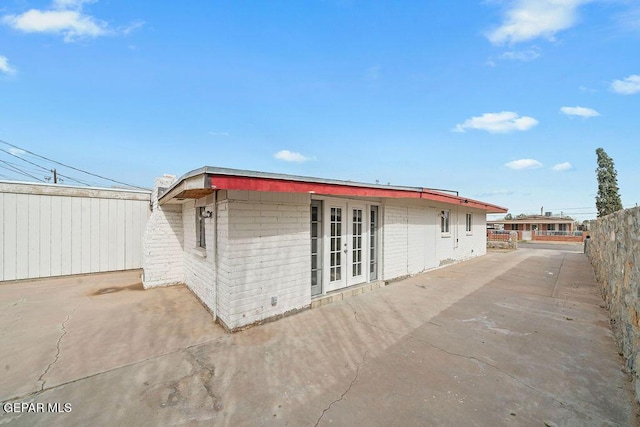 back of property with french doors, a patio, and fence