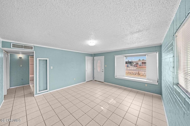 unfurnished room featuring tile patterned floors, visible vents, a textured ceiling, and crown molding