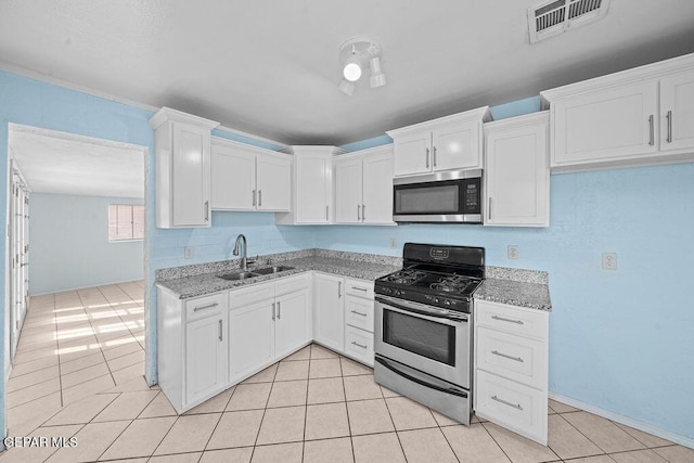 kitchen with light stone counters, visible vents, stainless steel appliances, and a sink