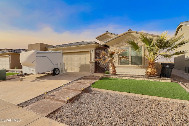 view of front of house featuring an attached garage, stucco siding, concrete driveway, stone siding, and a tiled roof