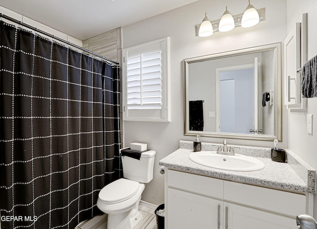 full bathroom featuring a shower with shower curtain, toilet, and vanity