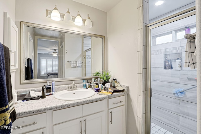 bathroom with a stall shower, vanity, and a ceiling fan