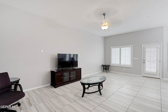 living room with baseboards and ceiling fan