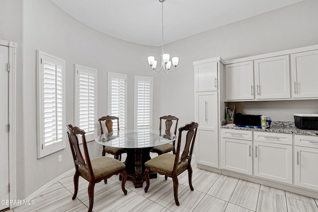 dining room featuring baseboards and a chandelier