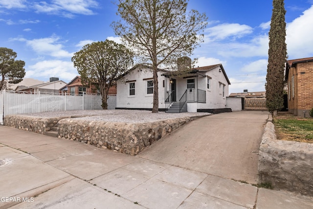 view of front of house featuring a gate, stucco siding, and fence