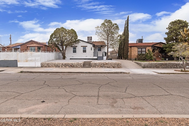 view of front of property with a gate, driveway, and a fenced front yard