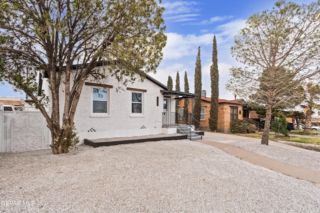 view of front of property featuring brick siding and fence