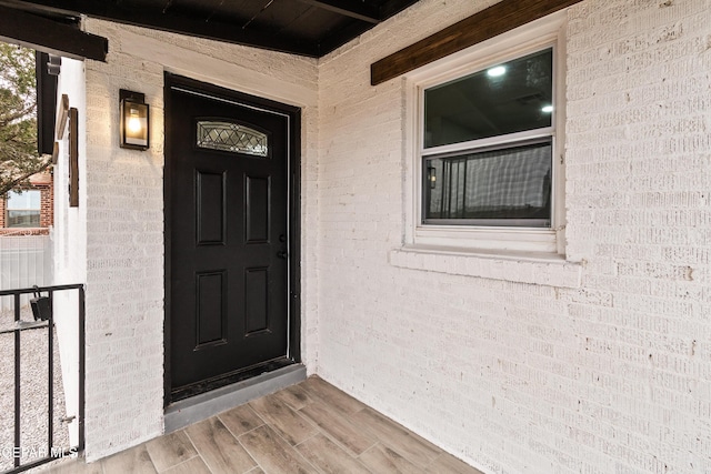 doorway to property featuring brick siding