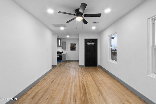 interior space featuring visible vents, baseboards, light wood-style floors, and ceiling fan