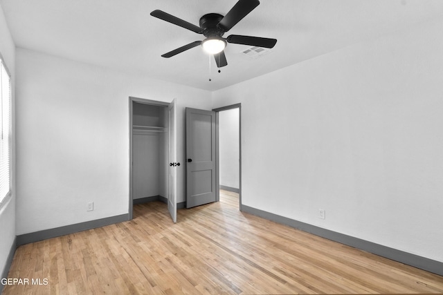 unfurnished bedroom featuring a closet, baseboards, light wood-style floors, and visible vents