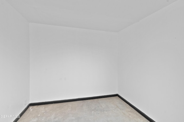 spare room with baseboards and concrete floors