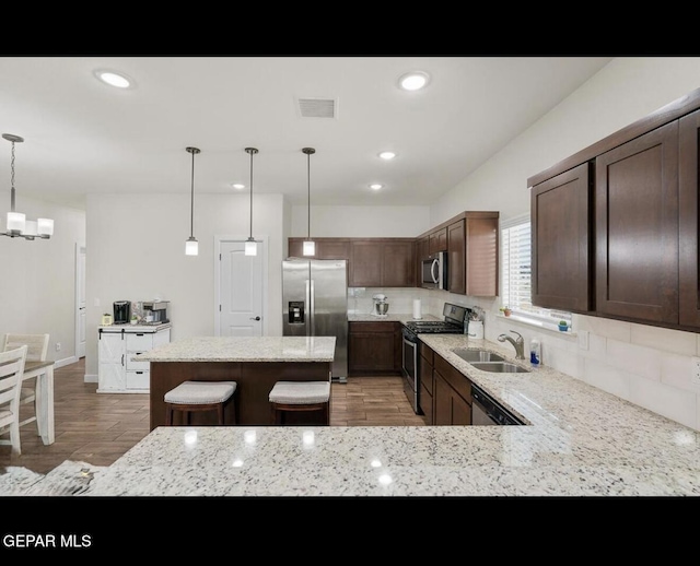 kitchen with tasteful backsplash, visible vents, an inviting chandelier, stainless steel appliances, and a sink