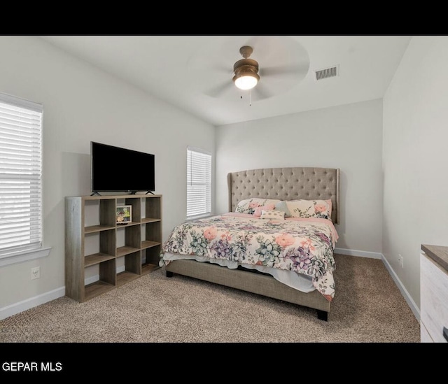 carpeted bedroom with visible vents, baseboards, and ceiling fan