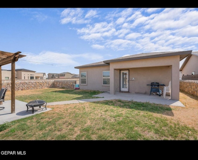 back of property featuring a patio, fence, a lawn, and an outdoor fire pit