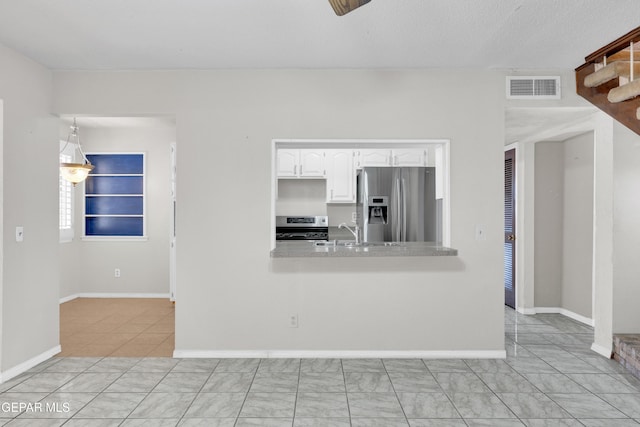 kitchen with visible vents, a sink, white cabinetry, stainless steel appliances, and light countertops