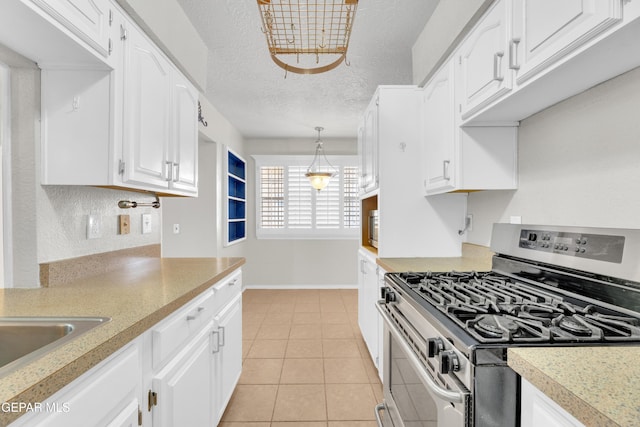 kitchen featuring a textured ceiling, white cabinets, light countertops, light tile patterned floors, and stainless steel range with gas stovetop