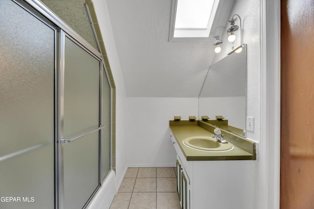 bathroom featuring tile patterned flooring, vaulted ceiling, vanity, and a shower with door