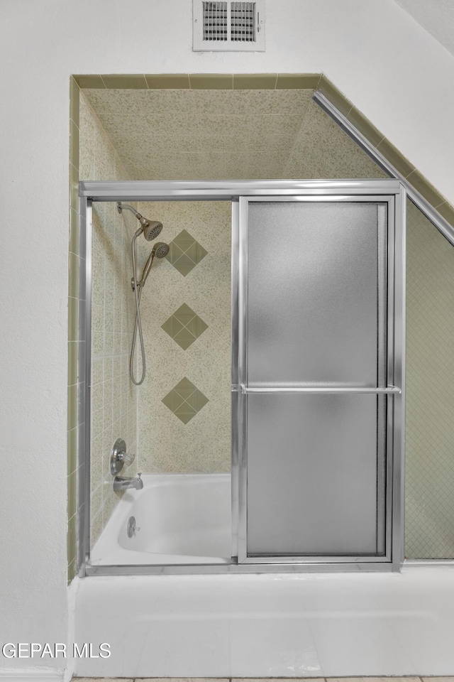 full bathroom featuring combined bath / shower with glass door and visible vents