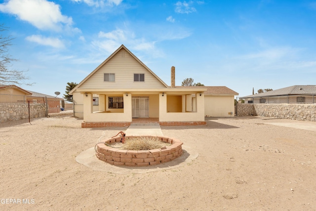 rear view of property featuring stucco siding and fence